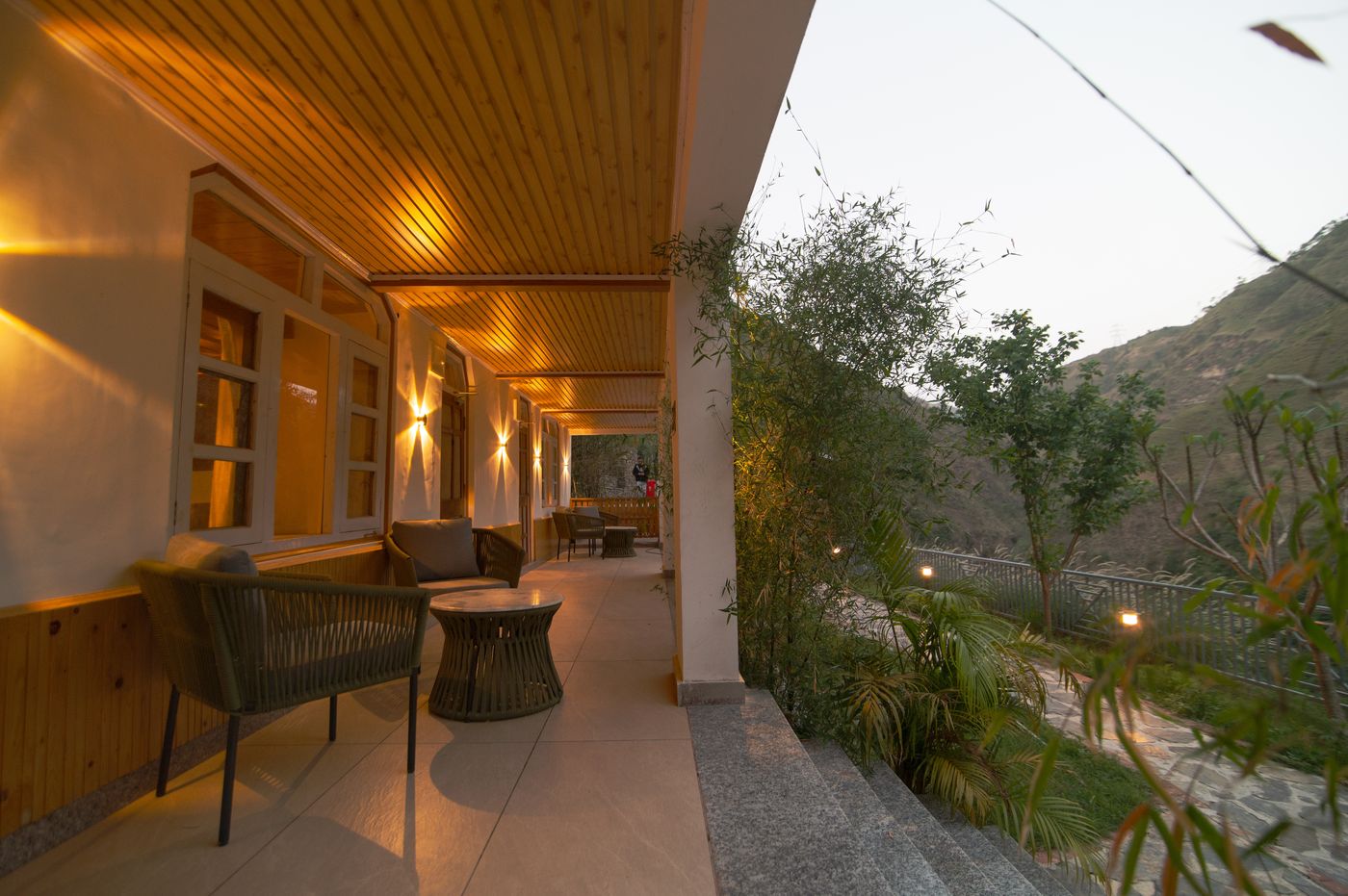 The warm-lit veranda corridor overlooking the hills at Giri River Retreat